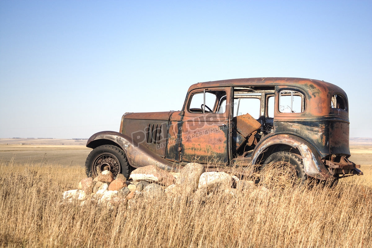 Grandpas old car sits atop a pile of rocks
