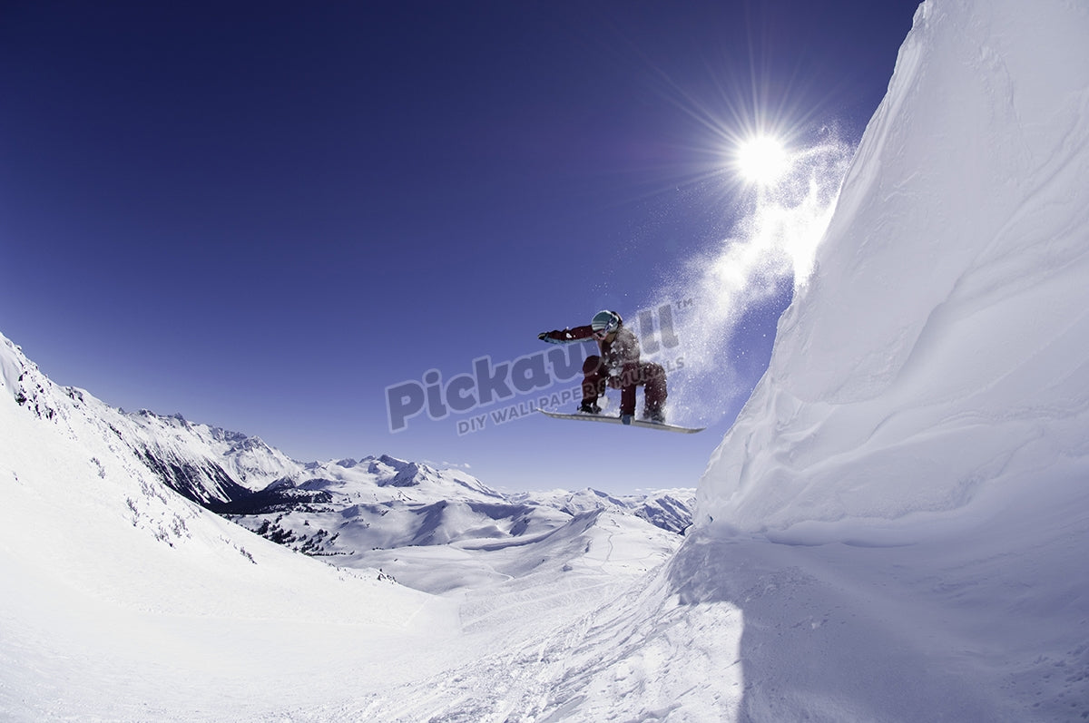 Female snowboarder jumping off cornice, low angle view