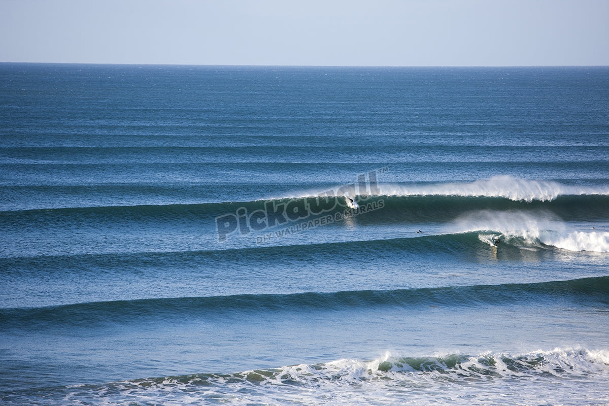 Surfer taking off on perfect wave